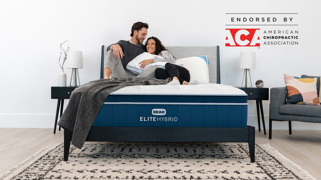 Bear Elite Hybrid mattress with couple relaxing together, endorsed by the American Chiropractic Association for The Mattress Shop, showcasing product image Bear Elite Hybrid on the page: Best Mattresses 2026 page.