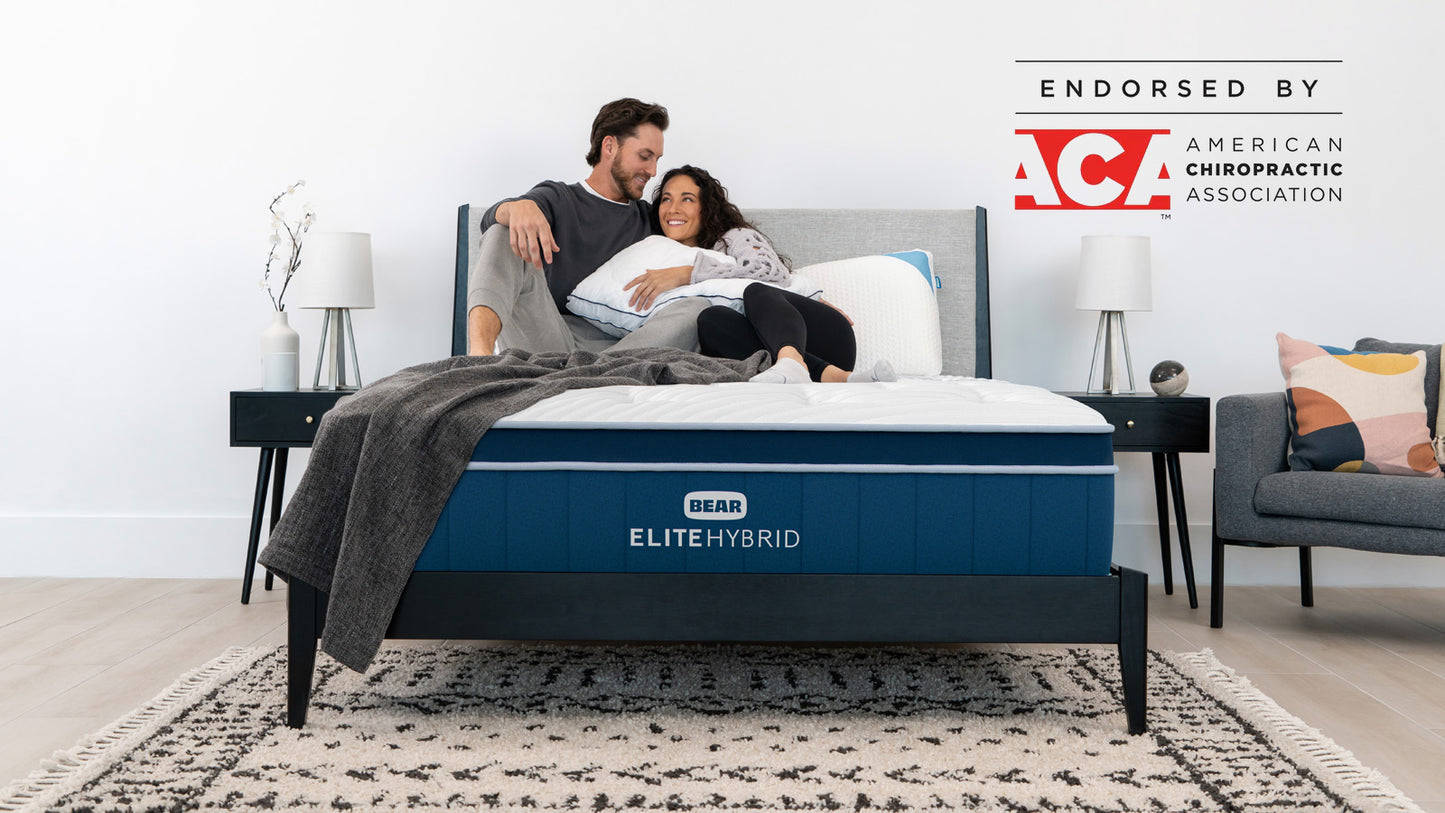 Bear Elite Hybrid mattress with couple relaxing together, endorsed by the American Chiropractic Association for The Mattress Shop, showcasing product image for Bear Elite Hybrid on the product page.