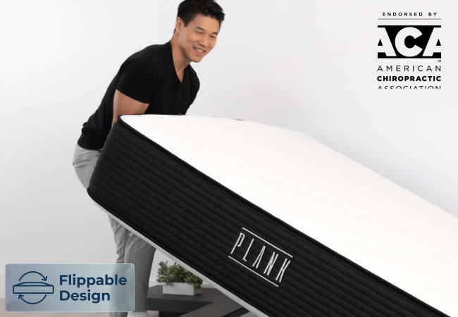 Brooklyn Bedding Plank flippable mattress design, endorsed by American Chiropractic Association, man flipping mattress for The Mattress Shop, showcasing product image for Brooklyn Bedding Plank Firm on the product page.