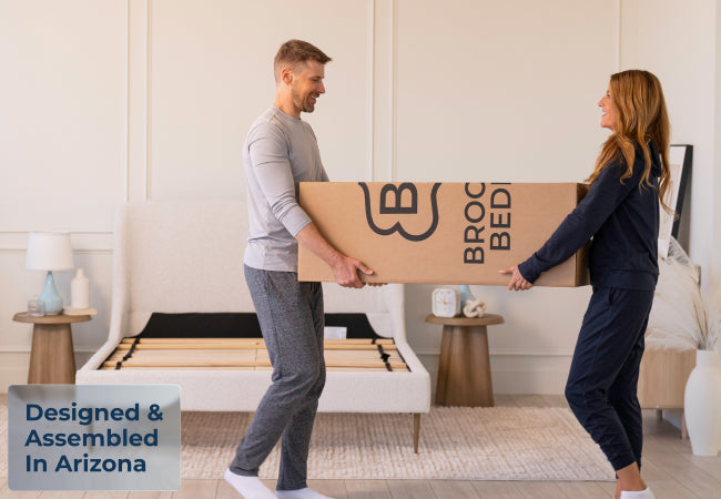 Brooklyn Bedding ThermoBalance mattress in box carried by couple, designed and assembled in Arizona. for The Mattress Shop, showcasing product image for Brooklyn Bedding ThermoBalance on the product page.