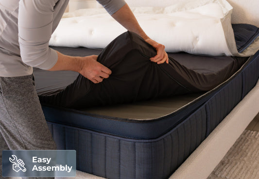 Brooklyn Bedding ThermoBalance Elite mattress easy assembly, man attaching pillow top to navy base. for The Mattress Shop, showcasing product image for Brooklyn Bedding ThermoBalance Elite on the collection page.