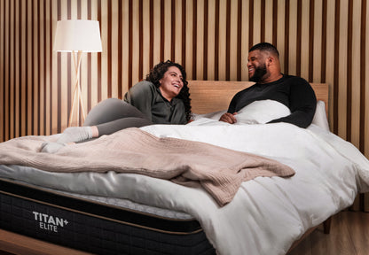 Brooklyn Bedding Titan Plus Elite mattress, couple laughing together in bed in modern wood panel bedroom