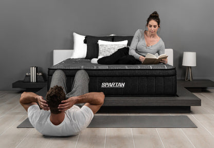 Brooklyn Bedding Spartan mattress, workout-inspired recovery sleep, man doing sit-ups while woman reads on bed.