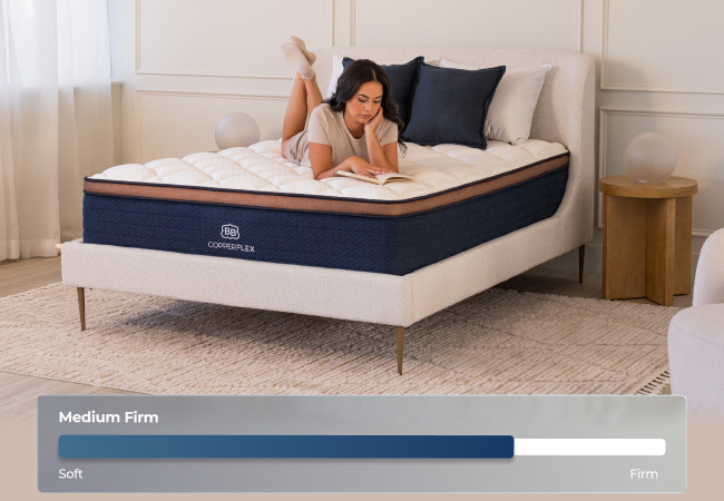 Brooklyn Bedding CopperFlex Pro medium firm mattress, woman lying on bed reading, firmness scale soft to firm for The Mattress Shop, showcasing product image Brooklyn Bedding CopperFlex® Pro on the page: Best Hybrid Mattresses page.