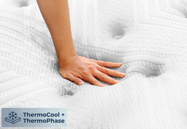 Brooklyn Bedding ThermoBalance LX Elite close-up with hand pressing into white pillow top, ThermoCool and ThermoPhase for The Mattress Shop, showcasing product image for Brooklyn Bedding ThermoBalance LX Elite on the product page.