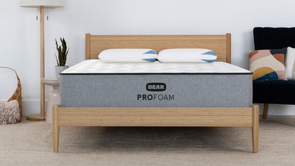 Bear Pro Foam mattress on bamboo bed frame in modern bedroom with floor lamp and navy accent chair