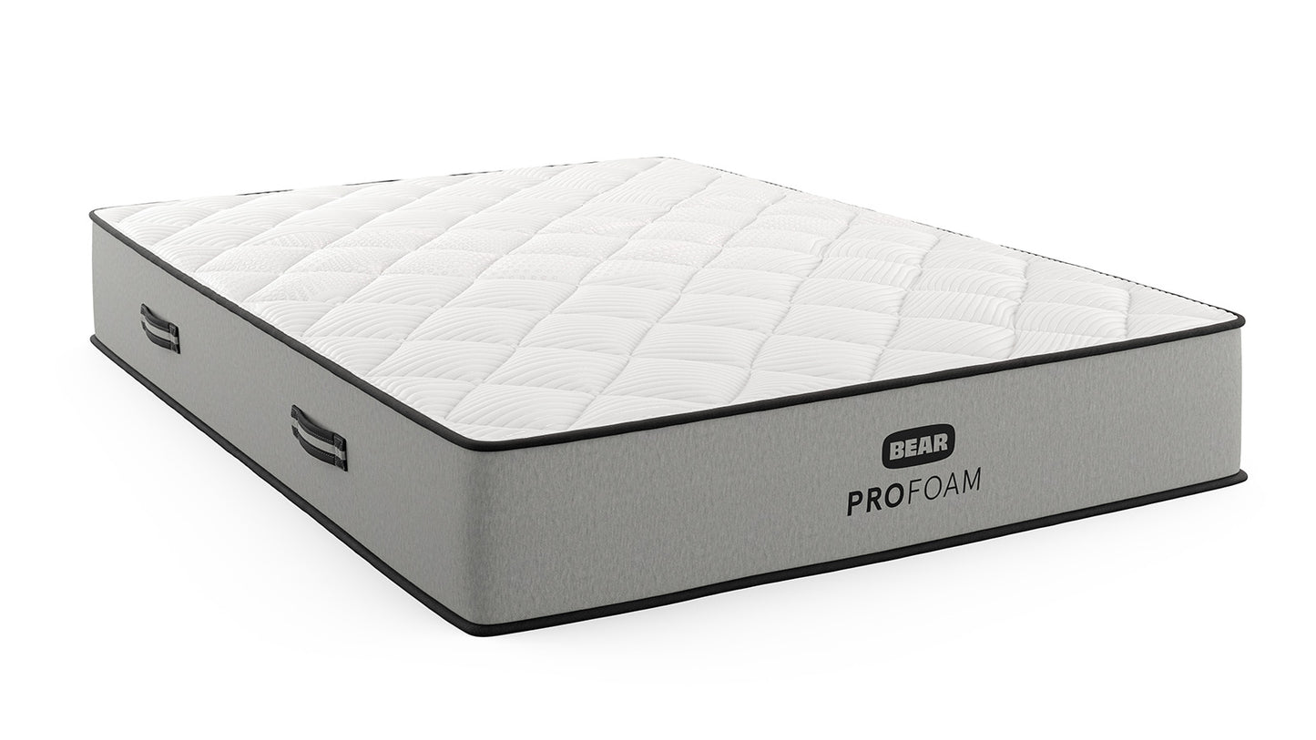 Bear Pro Foam mattress angled view with white quilted top, gray foundation, and side carry handles for The Mattress Shop, showcasing product image for Bear Pro Foam on the product page.