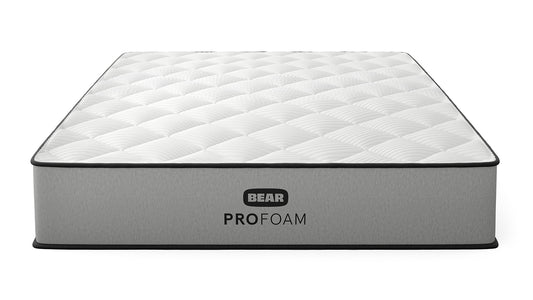 Bear Pro Foam mattress three-quarter front view with white quilted top and gray ribbed foundation for The Mattress Shop, showcasing product image for Bear Pro Foam on the collection page.