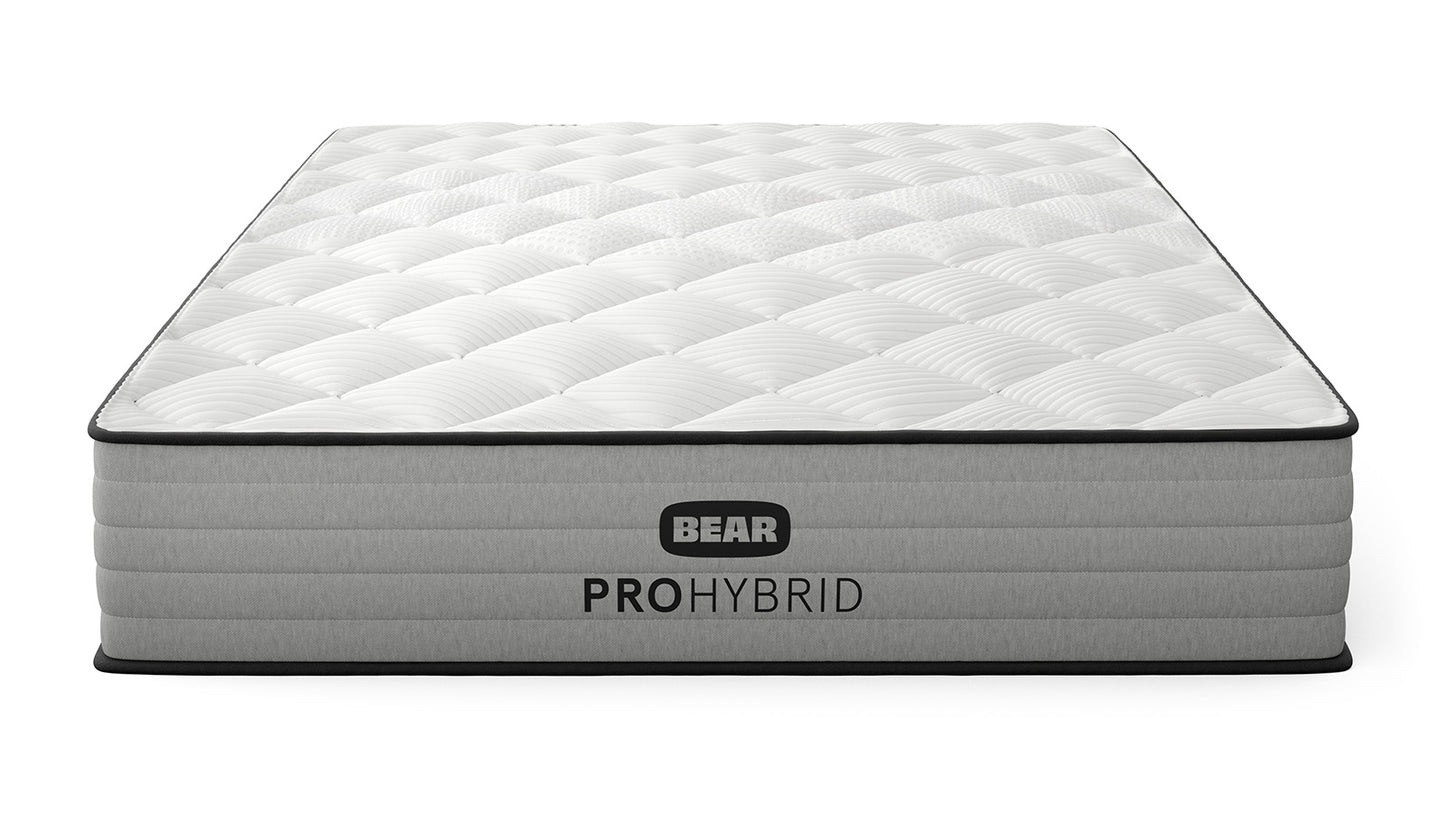Bear Pro Hybrid Mattress three-quarter front view with white quilted pillow top and gray ribbed foundation for The Mattress Shop, showcasing product image for Bear Pro Hybrid on the product page.