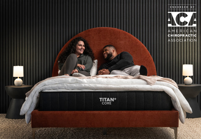Brooklyn Bedding Titan+ Core mattress on bed with couple relaxing, ACA chiropractic association endorsed. for The Mattress Shop, showcasing product thumbnail image for Brooklyn Bedding Titan Plus Core on the product page.