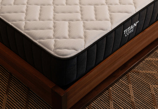 Brooklyn Bedding Titan+ Core mattress corner detail showing quilted top and side panel stitching on wood frame. for The Mattress Shop, showcasing product image for Brooklyn Bedding Titan Plus Core on the collection page.