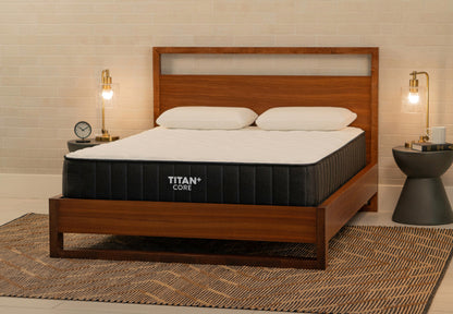 Brooklyn Bedding Titan+ Core mattress on wooden bed frame with white pillows in warm modern bedroom.