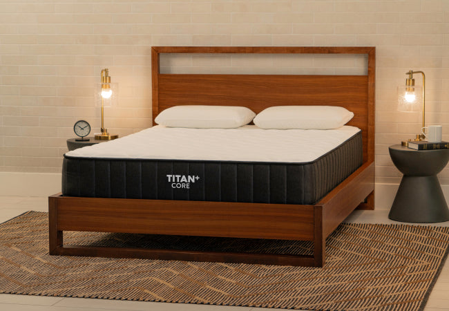 Brooklyn Bedding Titan+ Core mattress on wooden bed frame with white pillows in warm modern bedroom. for The Mattress Shop, showcasing product thumbnail image for Brooklyn Bedding Titan Plus Core on the product page.