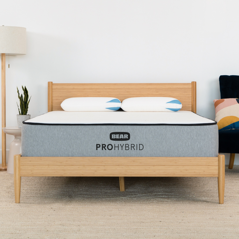 Bear Pro Hybrid mattress on a wooden bed frame in a room setting.