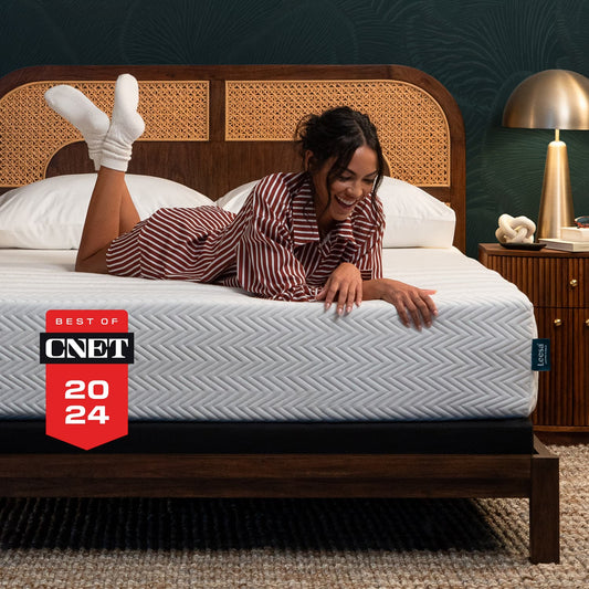 Woman on the Leesa Legend Hybrid Mattress in a bedroom.
