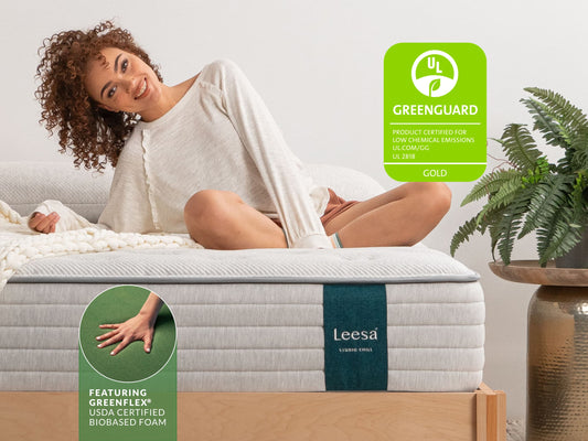 Woman sitting on Leesa Studio Chill mattress, UL Greenguard Gold certified with USDA certified biobased foam. for The Mattress Shop, showcasing product image for Leesa Studio Chill Hybrid Mattress on the page: About Leesa page.