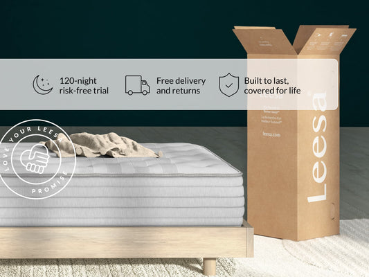 Leesa Studio Chill mattress on wood bed frame with towel, shipping box shows Love Your Leesa Promise guarantee. for The Mattress Shop, showcasing product image for Leesa Studio Chill Hybrid Mattress on the collection page.
