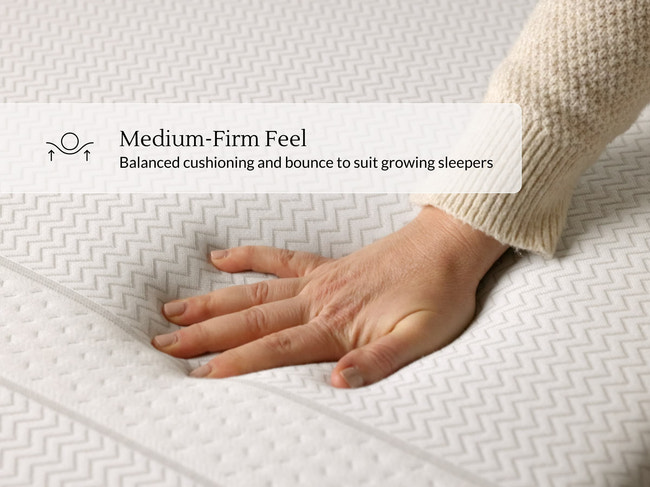 Hand pressing into quilted Leesa Kids mattress cover, showing balanced medium-firm feel for growing sleepers. for The Mattress Shop, showcasing product image Leesa Kids Mattress on the page: Best Mattresses for Kids page.