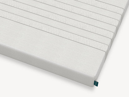 Corner detail of Leesa Kids mattress showing chevron-textured cover and brand label.