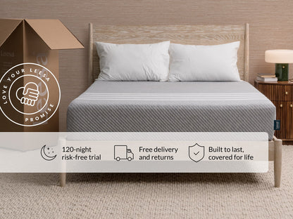 Leesa Original Hybrid mattress on wood bed frame with white pillows, shipping box shows Love Your Leesa Promise.