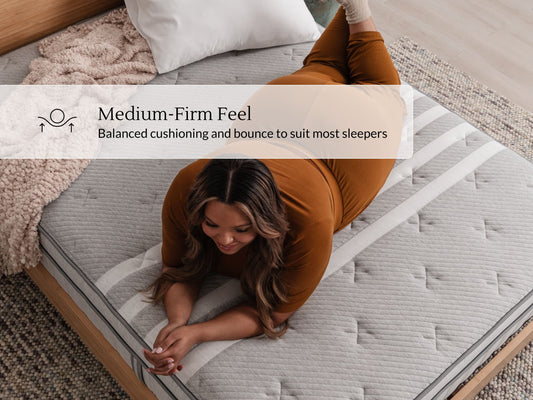 Woman kneeling on Leesa Plus Hybrid mattress with striped cover, showing balanced medium-firm feel. for The Mattress Shop, showcasing product image for Leesa Plus Hybrid Mattress on the collection page.