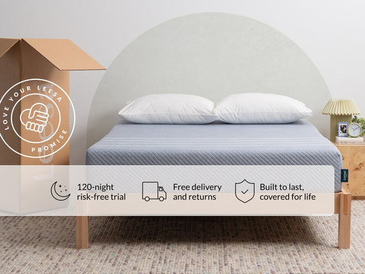 Leesa Studio mattress on bed with white pillows, shipping box shows Love Your Leesa Promise guarantee. for The Mattress Shop, showcasing product image for Leesa Studio Mattress on the collection page.