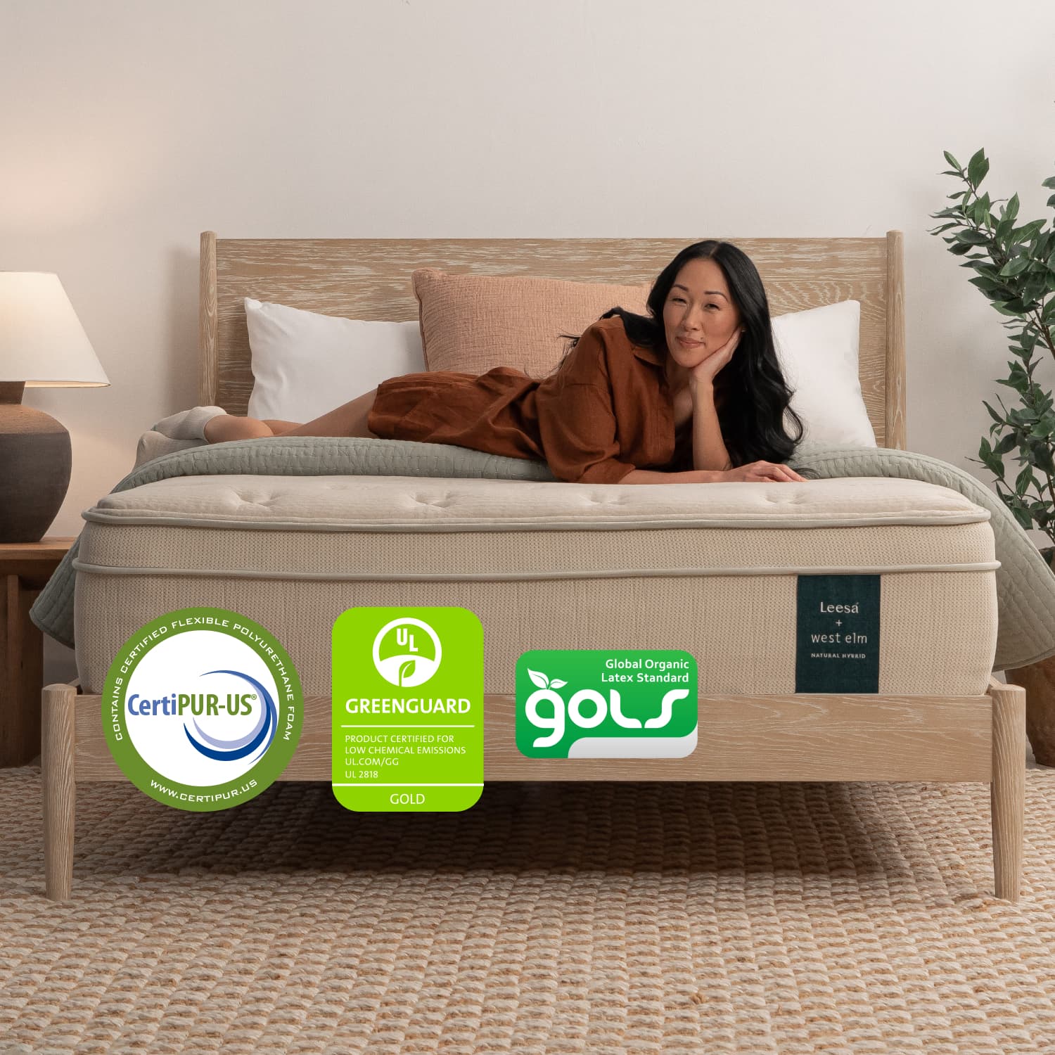Woman on the Leesa Natural Hybrid Mattress in a bedroom.
